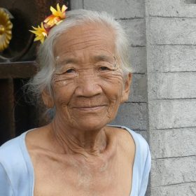 woman in white tank top with yellow flower on her ear